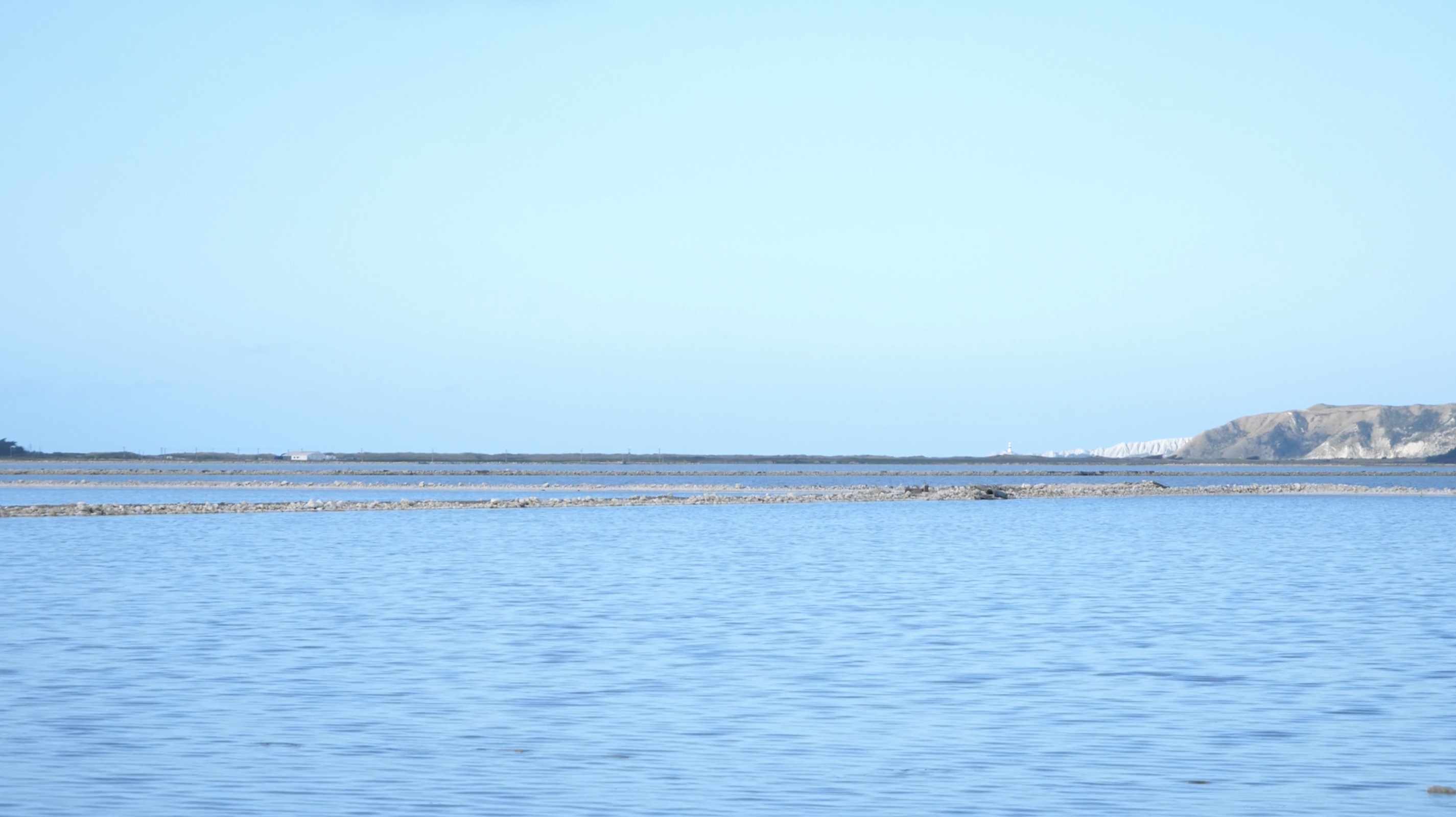 A photo of a lake with a very blue sky
