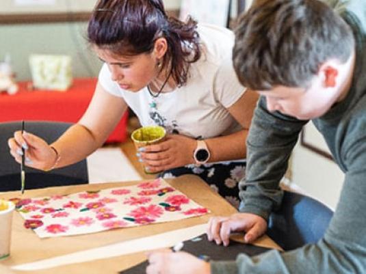 Two young people painting at a table