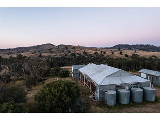 agricultural sheds surrounded by trees and rolling hills