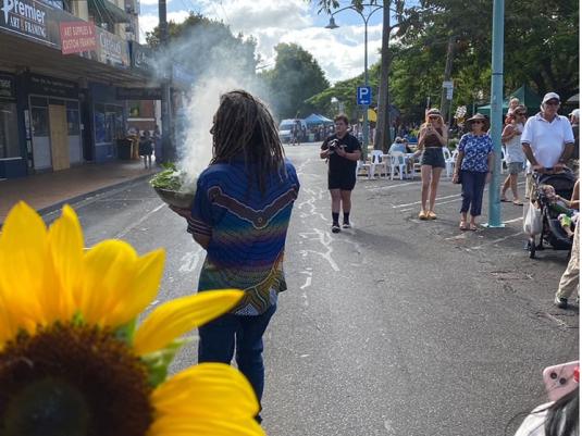 Uncle Gilbert performing smoking ceremony in town street