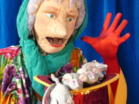 puppet of old woman with a plate of mice