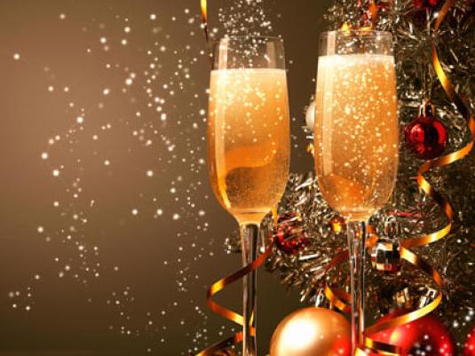 two glasses of sparkling wine in front of christmas decorations