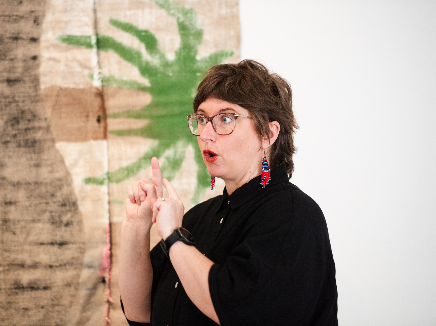 Sigrid Macdonald signing, in front of artworks by Mark Maurangi Carrol. Photo by Elise Derwin