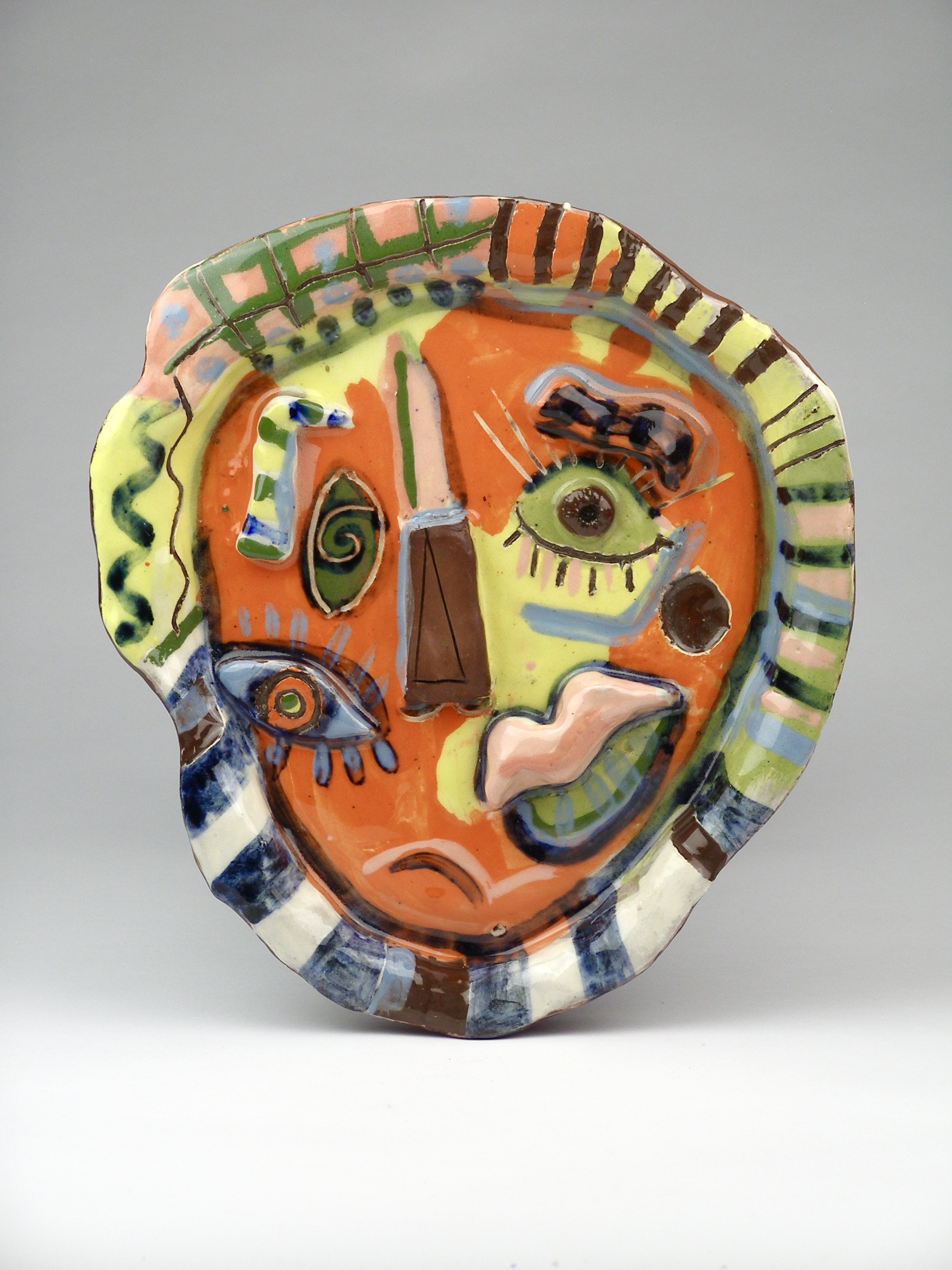 A colourful and Picasso-style painted ceramic plate