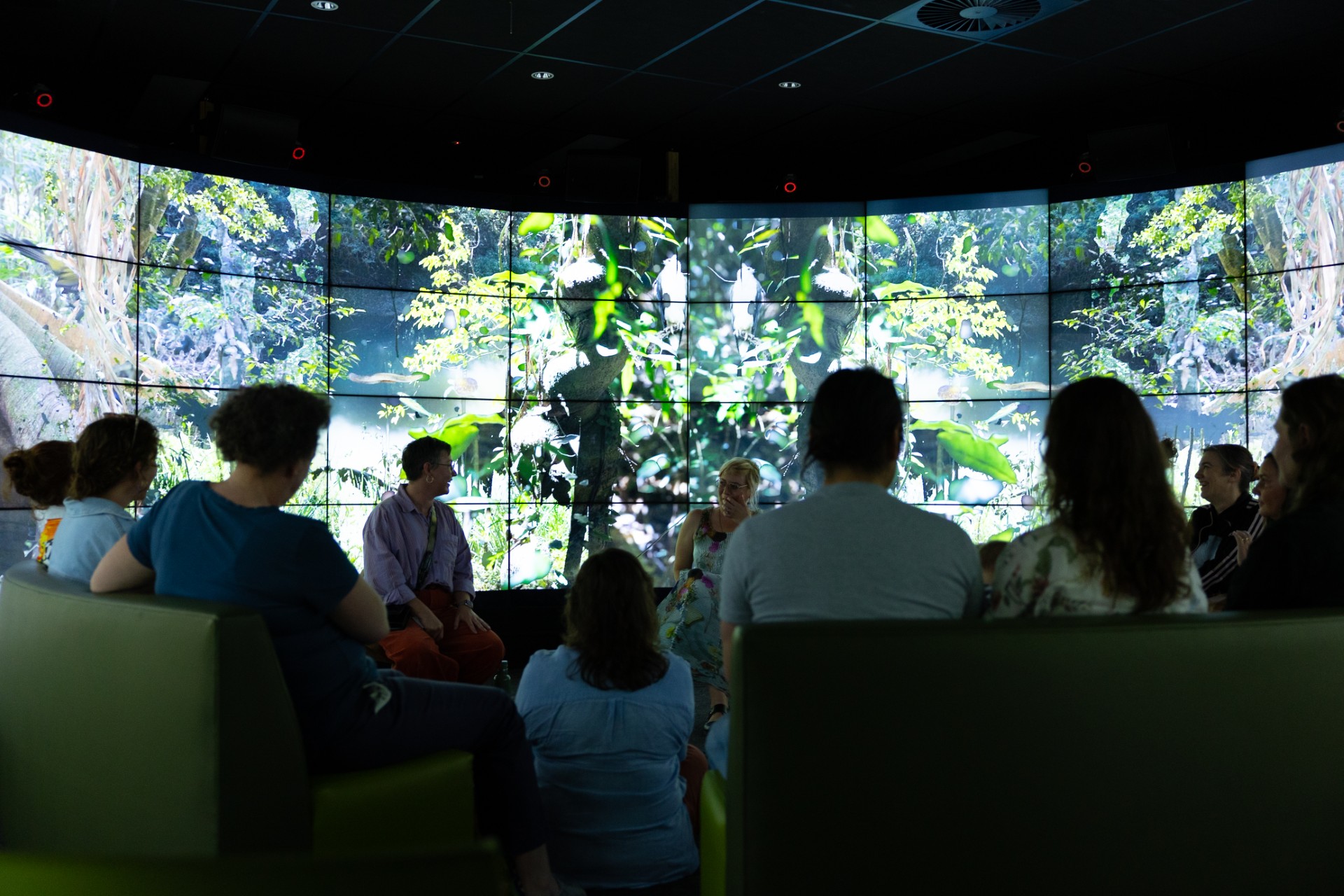 A room of people looking at a large projection