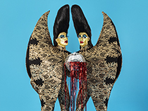 Two figures with gold faces, high 'beehive' hair, and a single set of large wings shared by the two figures.