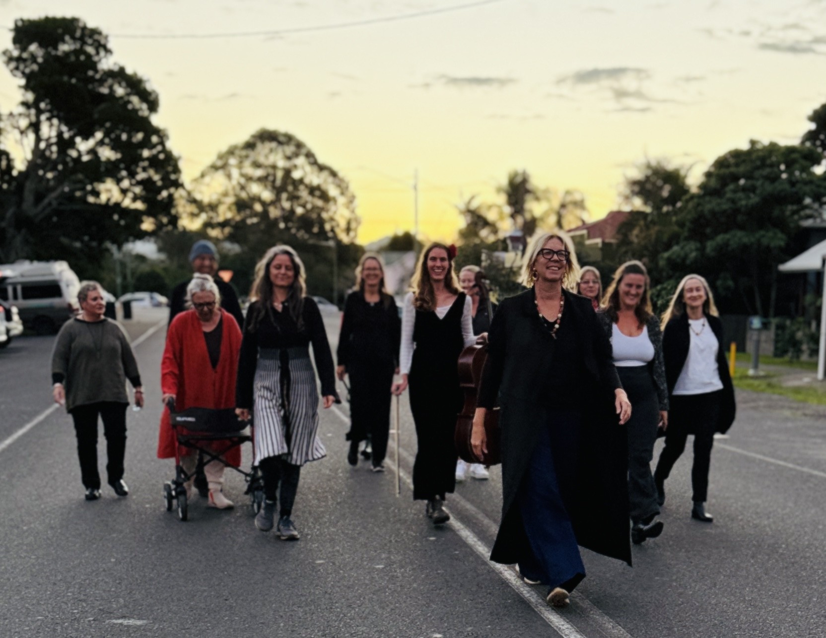 A group of older women walking down the street with the sunset behind them 