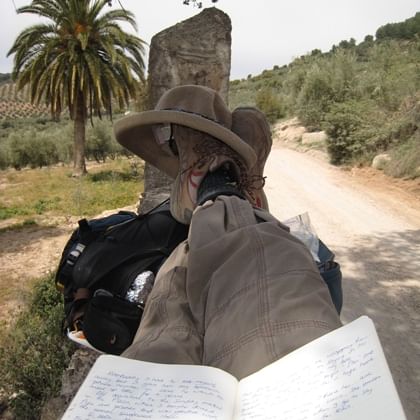 person resting on the trail with feet up on back packs