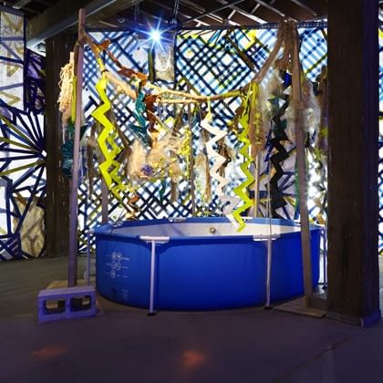 swimming pool with jungle themed background constructed with found objects