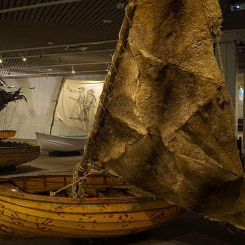 boat with animal skin sails in foreground with another boat behind