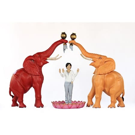 two elephants making arch with trunks with woman standing beneath it lotus flower