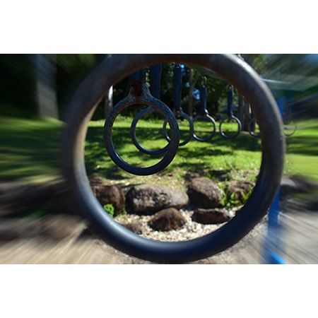 large circle in foreground with a row of hanging monkey bar rings going back into the distance int