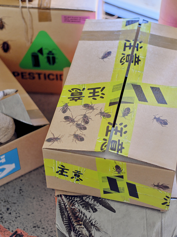 A documentation image from an exhibition, picturing painted cardboard boxes