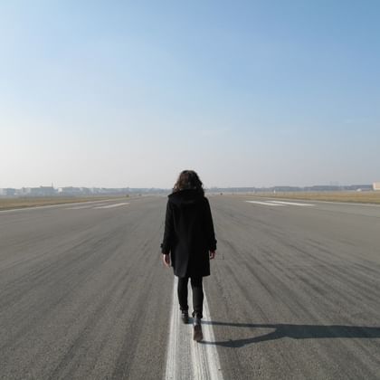 woman walking down the centreline of an airport runway