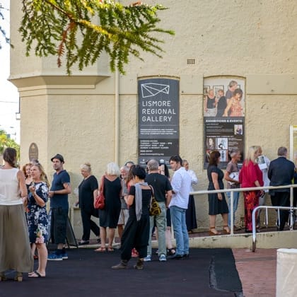 group of people gathering out the front of the gallery building 