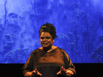 woman speaking in front of blue backdrop