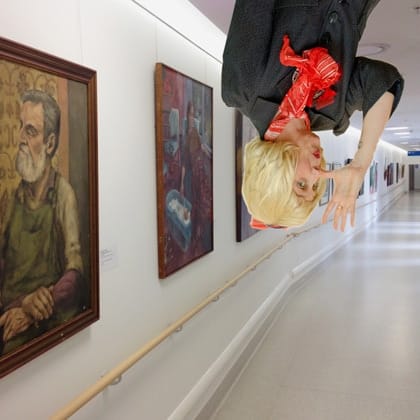upside down Peggy Popart in corridor of artworks 