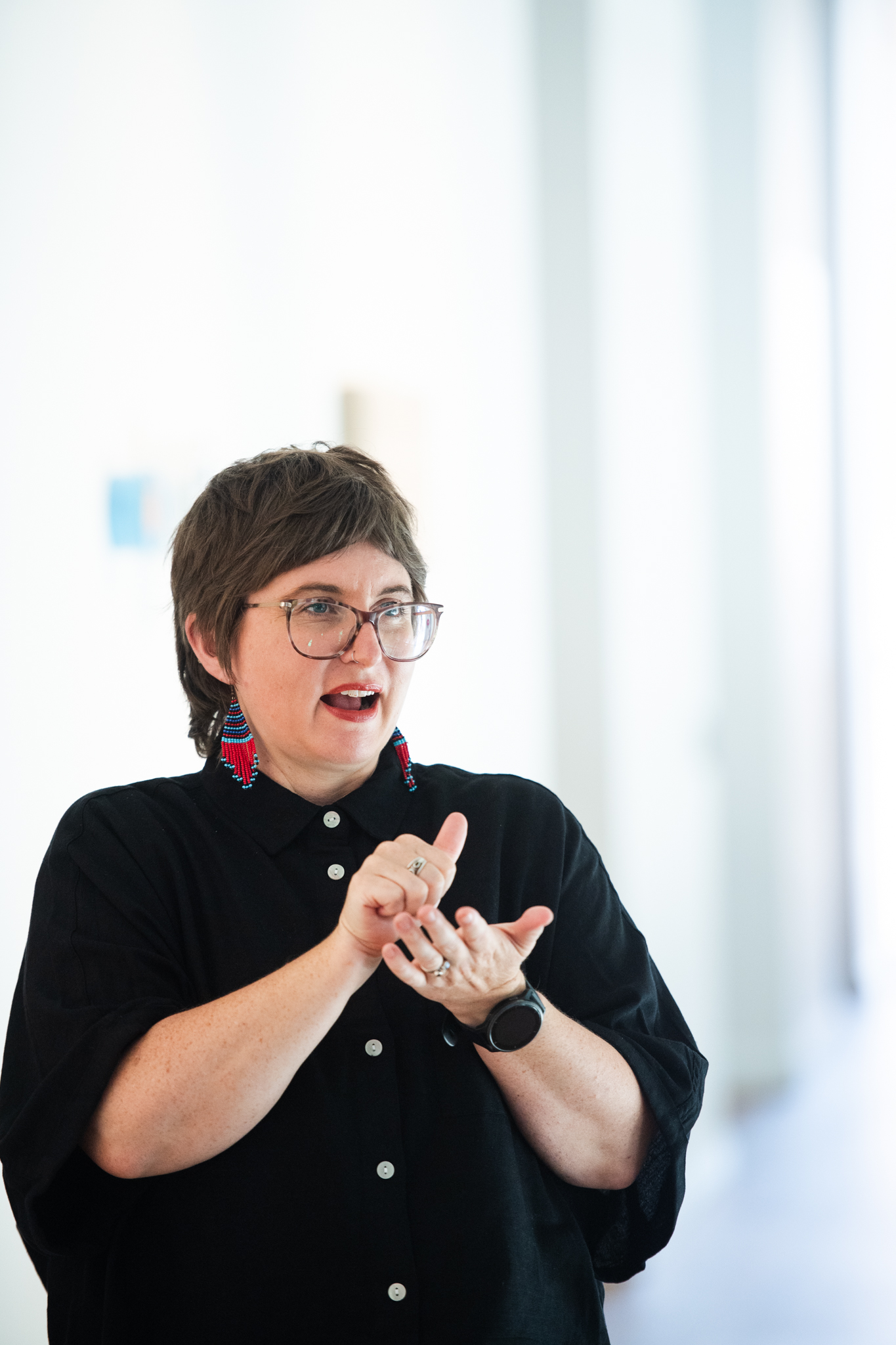 A woman signing in Auslan in a gallery