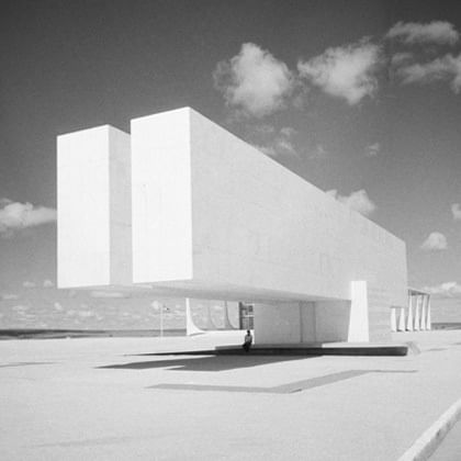 photograph of building that extends seemingly unsupported toward the viewer