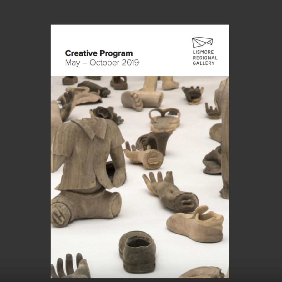 multiple wooden sculptures of of human body parts and clothing including hand, feet, shoes and a torso 