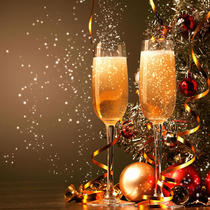 two glasses of sparkling wine in front of christmas decorations 