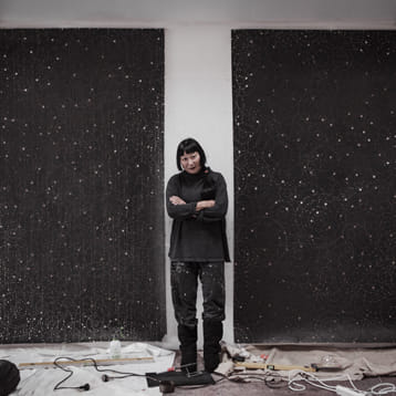 Artist Lindy Lee standing in gallery