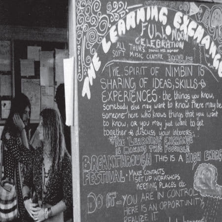 two people next to 'The Learning Exchange' blackboard at Aquarius Festival 