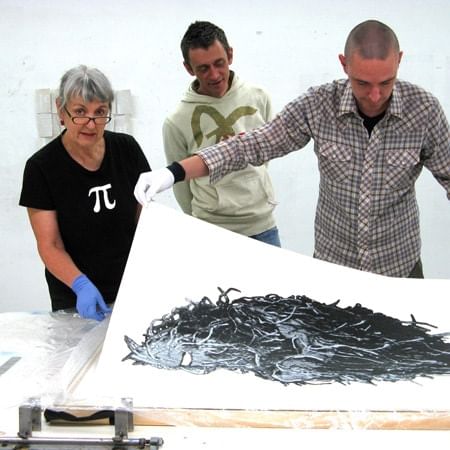 Jan Davis with wo men looking at an artwork 