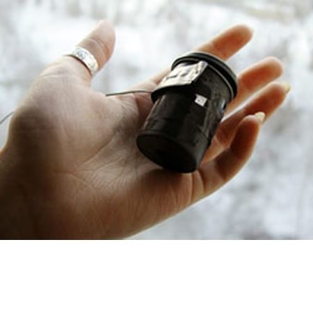 a hand with ring on the thumb with a film roll canister in the palm of hand 