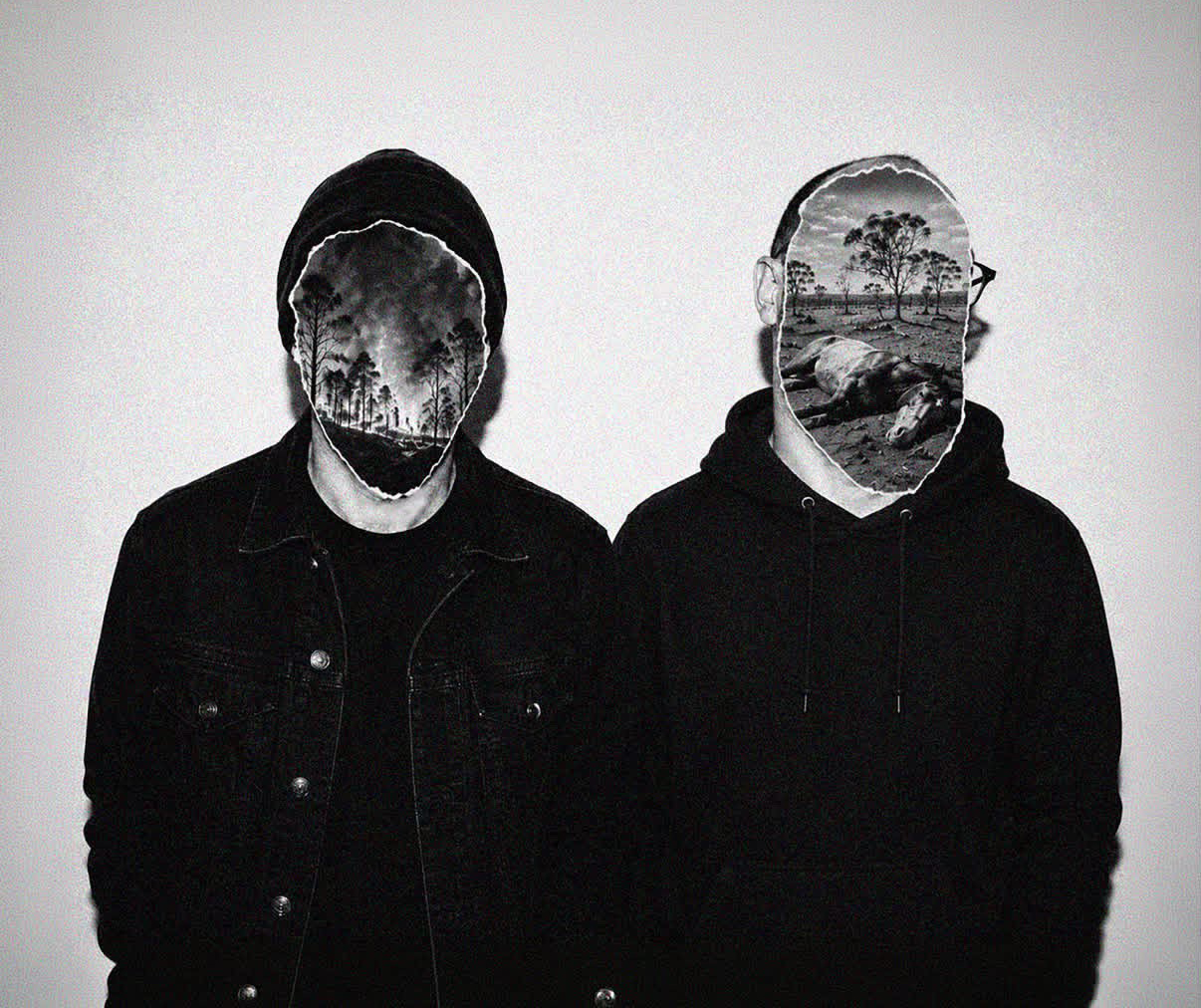 A black and white photo of two people wearing black hoodies against a white wall. Where their faces should be is a cut out photo of a landscape