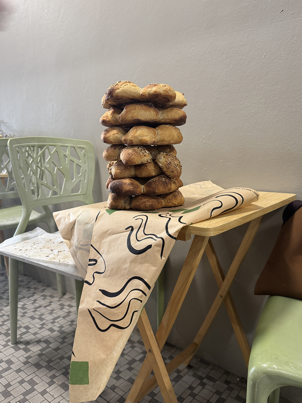 A photo of a stack of bread sitting on designed wrapper at a cafe table