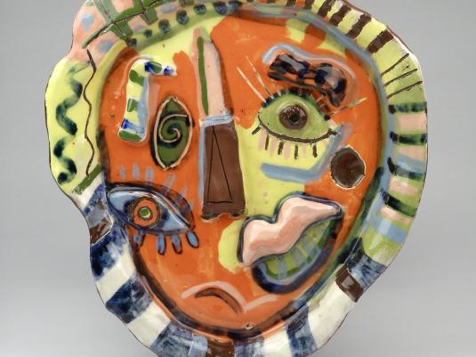 A colourful and Picasso-style painted ceramic plate