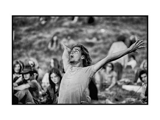 Man dancing in foreground with crowd behind.