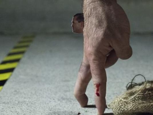 a hand with fingers walking and miniature man's head attached looking forward