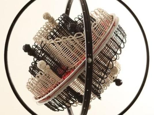 sculpture with bicycle rims  and woven form within them