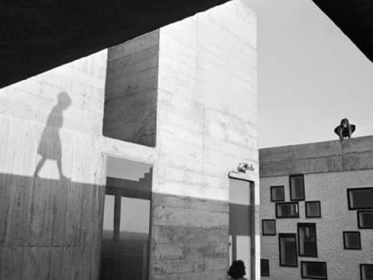 buildings with shadow of a child  and woman walking in the  foreground