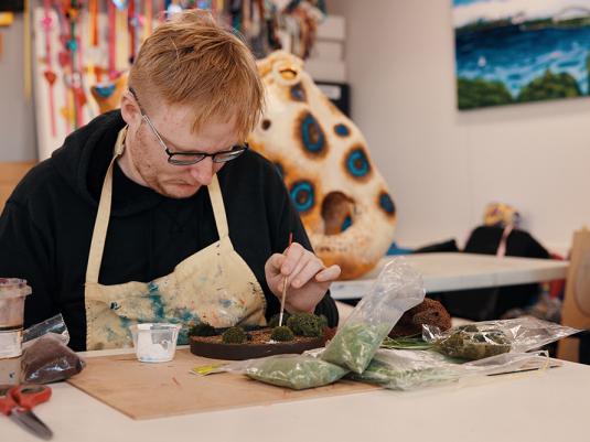 A man in an artist studio painting
