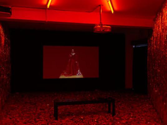 room with red lighting and red walls and floor with a large screen
