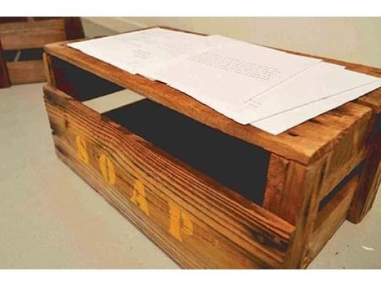 large soapbox with sheets of paper with text on top