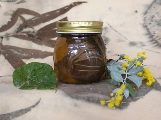 jar of natural dye with spray of wattle