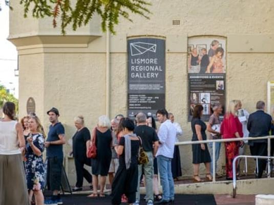 group of people gathering out the front of the gallery building