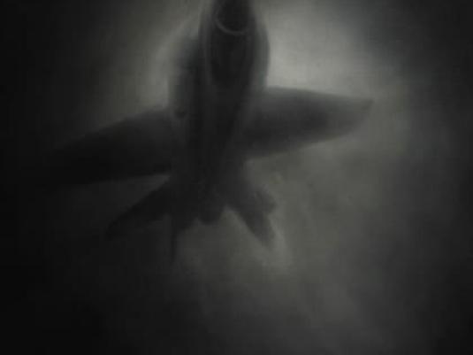 dimly lit image of plane in front of the moon