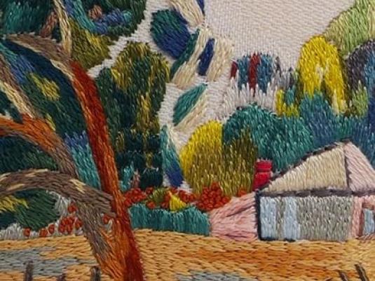 embroidery of landscape the a fence and shed with a tree in foreground and tree covered hill in background