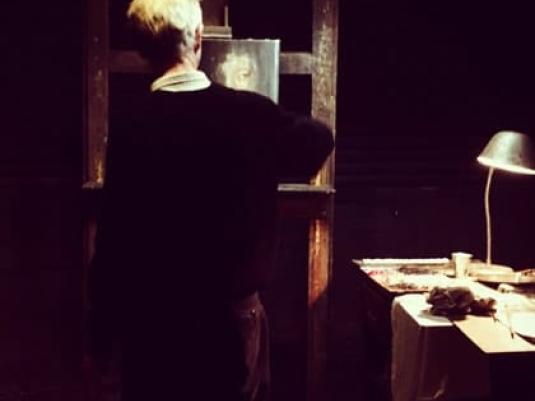 Rear view of artist painting in his studio