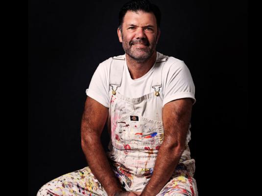 phto of Blak Douglas in paint splatters overalls