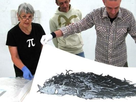 Jan Davis with wo men looking at an artwork