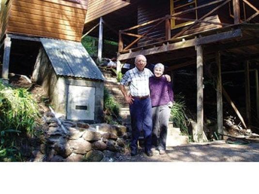Leigh and Ellen Davison out the front of their owner built timber home