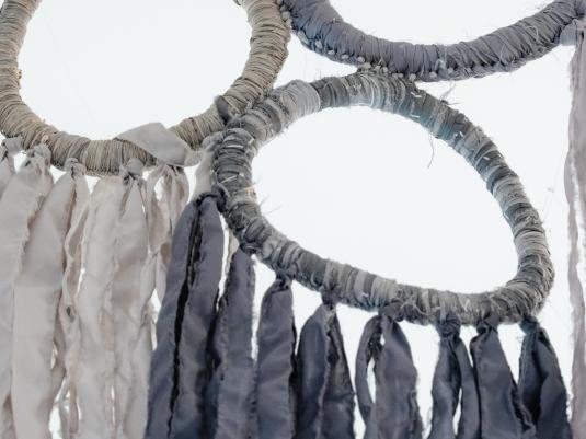 A fabric woven artwork in blues and greys