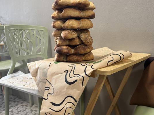 A photo of a stack of bread sitting on designed wrapper at a cafe table